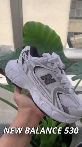 Tenis NB530 en color blanco y negro con diseño moderno y suela premium. Combinados con un outfit casual, mostrando su versatilidad.