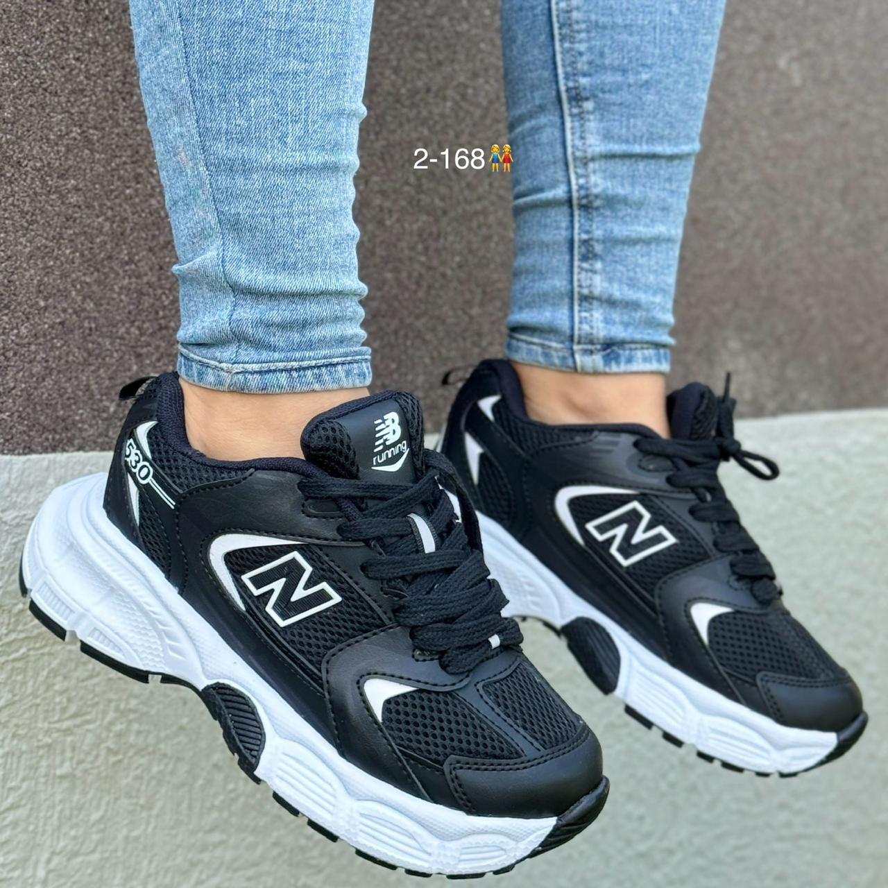 Tenis NB530 en color blanco y negro con diseño moderno y suela premium. Combinados con un outfit casual, mostrando su versatilidad.